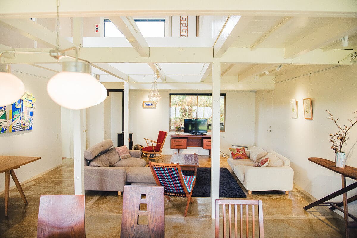 白く塗った壁と梁、高い吹き抜けが解放感たっぷりのリビングダイニング