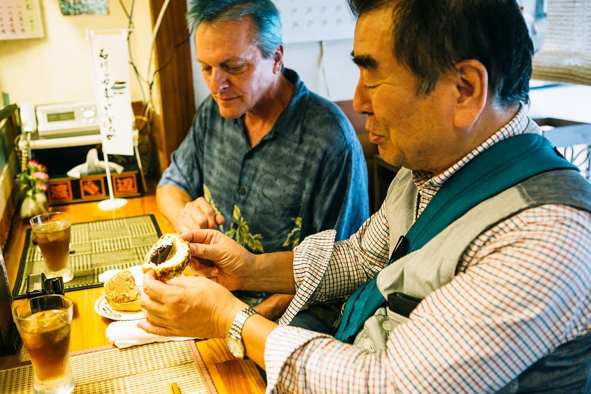 写真は、小諸駅そばにある、一信さんおすすめの天麩羅割烹、懐。揚げあんパンに舌鼓を打つ稔さん(右)と、アーティストのアランさん。