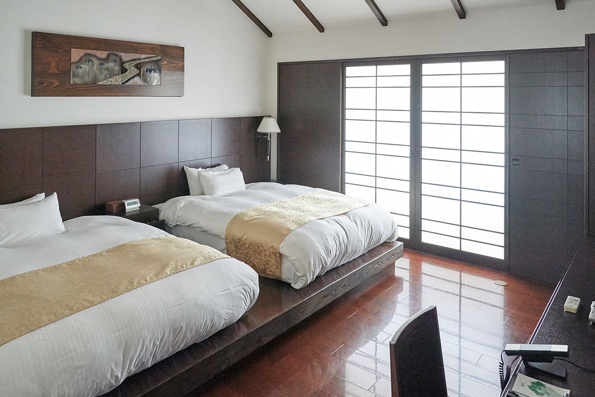 「癒しと快適な眠り」をテーマとした、ホテル白菊のスイートルーム「菊万葉」。吹き抜けの天井にはシーリングファンがあり、メゾネットの2階には専用の露天風呂があるなど、プライベートな空間でゆっくりと過ごせる。