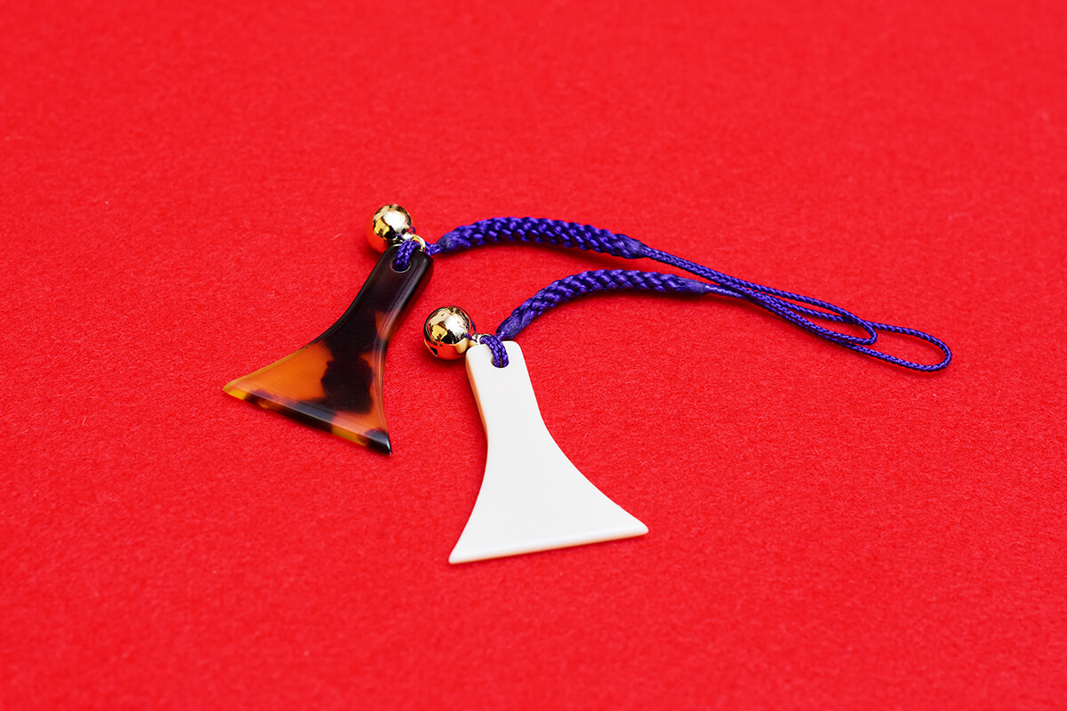 体験参加者は、三味線のバチ型の根付けをお土産としてもらえる。白とべっ甲の2種類からひとつを選ぶ。