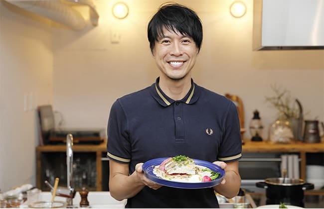 完成した料理の一品を手にもつコウさん